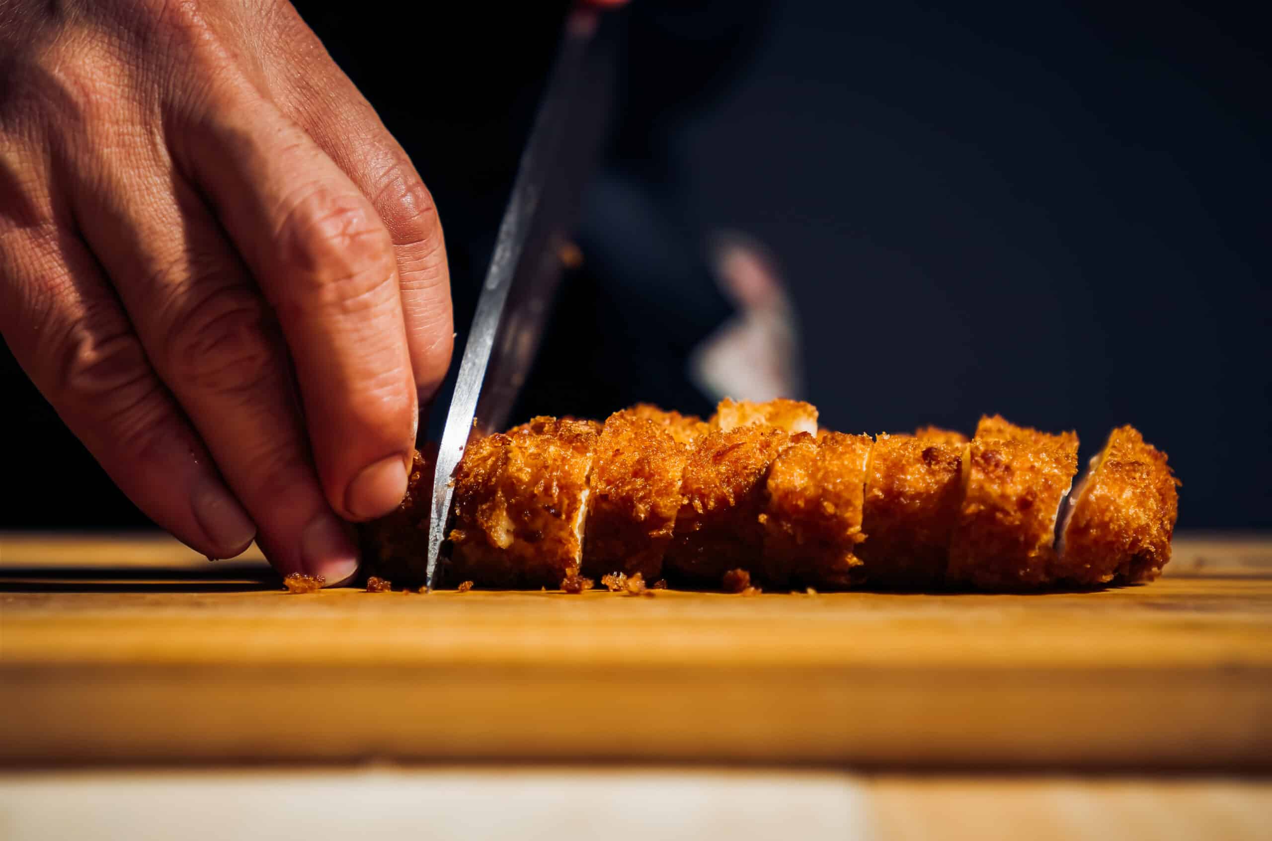 Japanese chicken katsu curry rice, deep fried breast chicken fillet with beef, carrot and potato curry in black plate on wooden table Crispy fried pork cutlet with curry rice  - Japanese food style